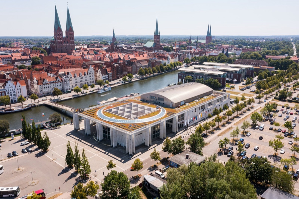 Luftbild der Musik- und Kongresshalle Lübeck an der Trave, dahinter die Türme der Altstadt